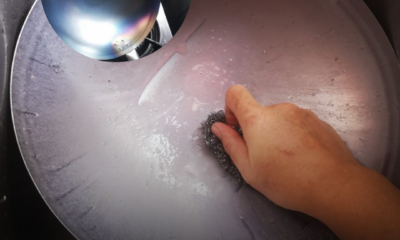 Cara mencuci kuali besi karbon baharu menggunakan span besi sebelum proses seasoning dilakukan.